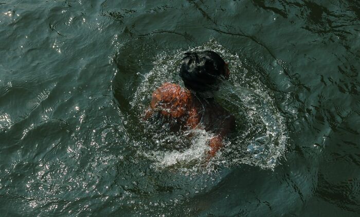 Person struggling in deep water, illustrating survival in crazy situations at sea or open water scenarios.