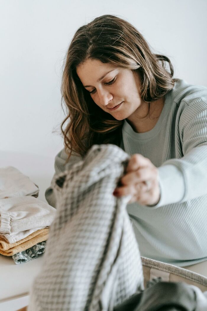 Woman sorting laundry indoors, representing snooping parents uncovering an unexpected side of their teen. - 25