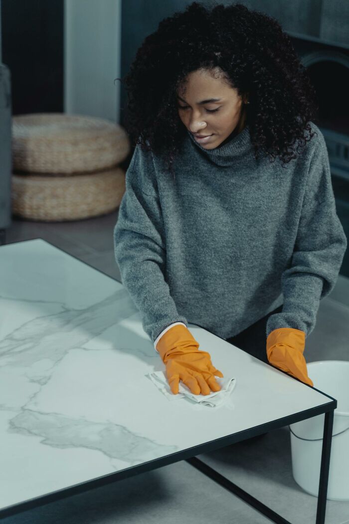 Woman wearing orange gloves cleaning a table, illustrating times people actually experienced psychic predictions.