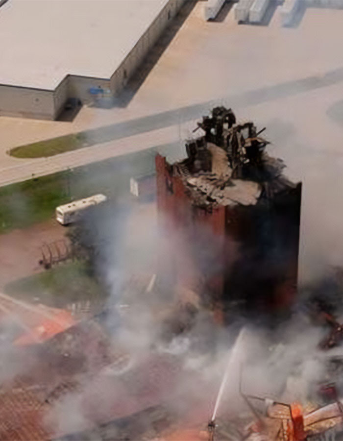 Aerial view of destruction and smoke from a horrific explosion in a building linked to a heartbreaking final phone call.