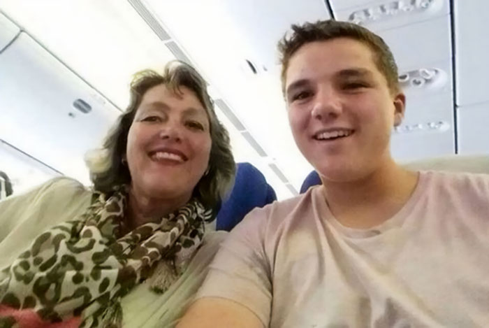 Woman and young man smiling together in an airplane seat, a photo taken before disaster on a flight journey.