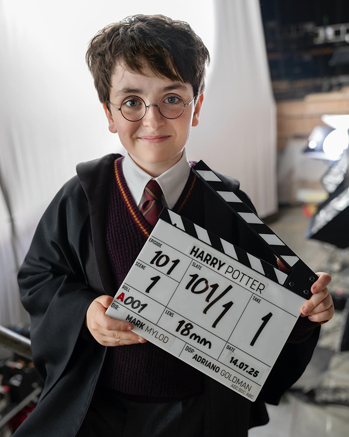 Young actor dressed as Harry Potter holding a clapperboard on the set, sparking new Harry Potter series reactions. Young actor dressed as Harry Potter holding a clapperboard on the set, sparking new Harry Potter series reactions.
