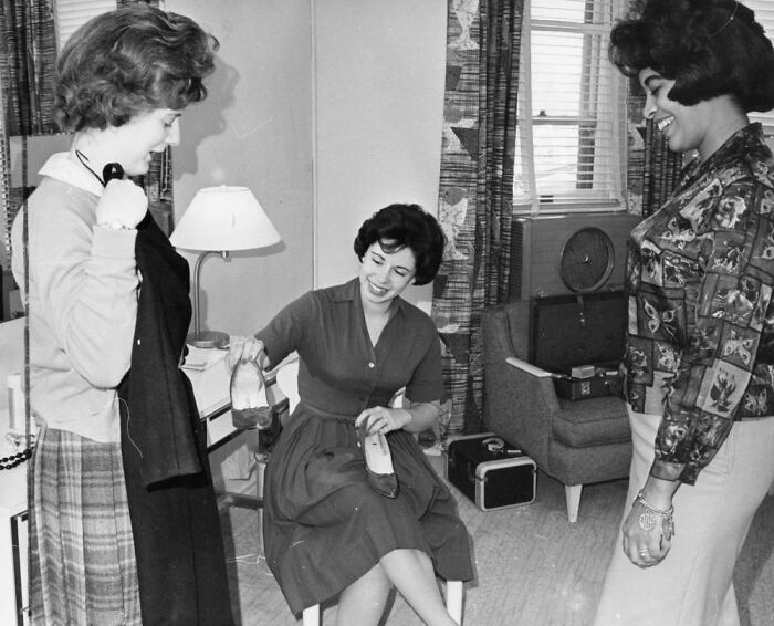Three LA women living their best lives in 1962, smiling and socializing in a cozy indoor setting.