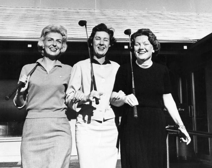 Three LA women from 1962 smiling and holding golf clubs, enjoying outdoor leisure and living their best lives together.