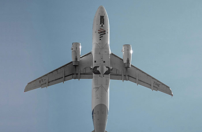 Airplane flying overhead against clear sky representing pilots facing terrifying situations in flight experiences.