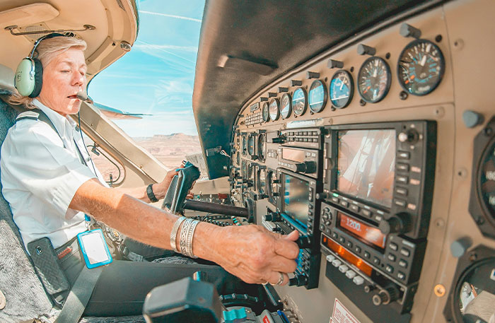 Pilot adjusting controls inside a small aircraft cockpit, focusing on managing a potentially terrifying situation during flight.