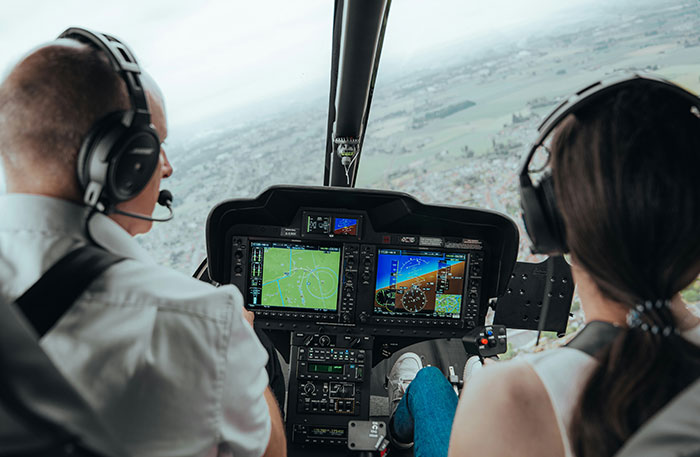 Two pilots wearing headsets inside a cockpit, navigating in a flight simulation of a terrifying situation.