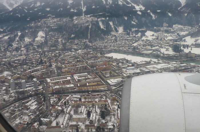 Aerial view from airplane window showing a snowy town and mountains, relating to pilots and terrifying situations.