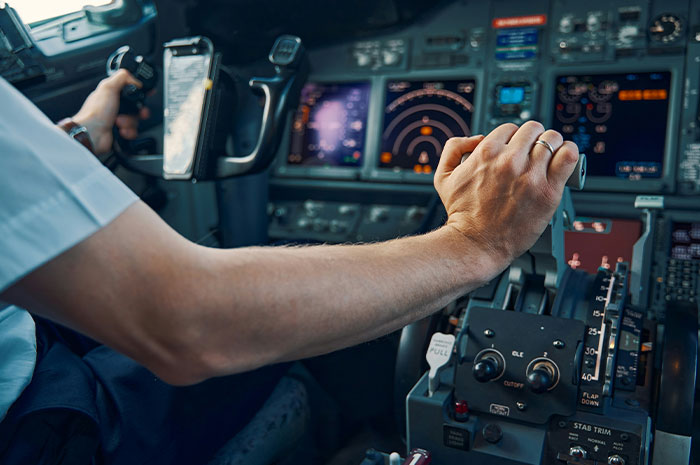 Pilot's hand gripping controls inside an airplane cockpit, illustrating a terrifying situation faced by pilots in flight.