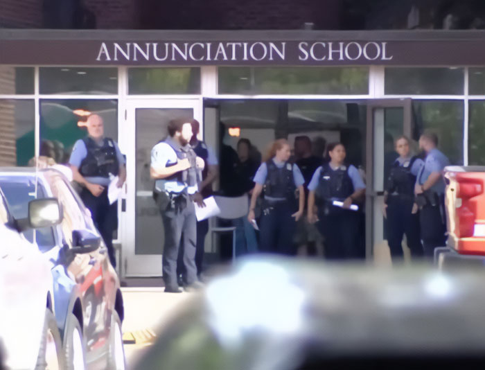 Police officers gather outside Annunciation School during the Minneapolis massacre investigation after culprit released disturbing manifesto.
