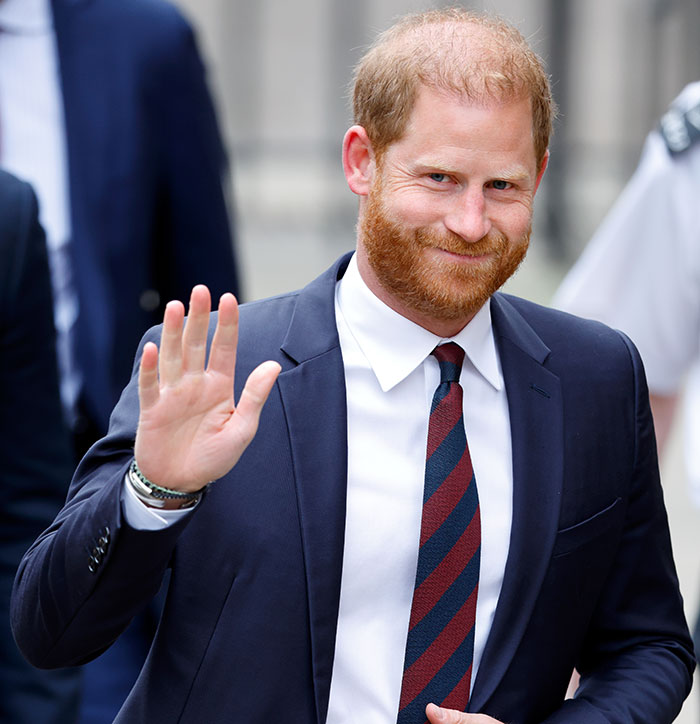 Prince Harry in a dark suit waving and smiling during public appearance amid Sentebale scandal investigation findings. - 1