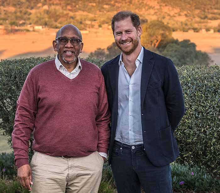 Prince Harry smiling outdoors with a man in casual attire, related to Sentebale scandal investigation findings. - 5