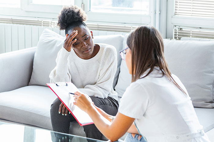 Woman looking baffled during a psychiatrist session as the psychiatrist makes an unhinged request in a bright office. Woman looking baffled during a psychiatrist session as the psychiatrist makes an unhinged request in a bright office.