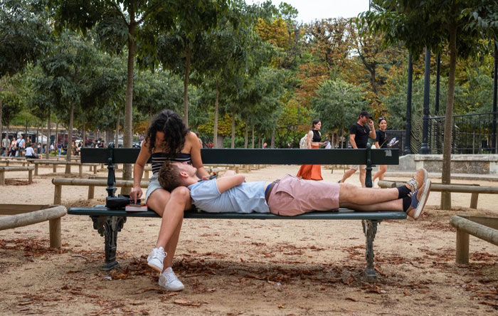 Couple relaxing on a park bench surrounded by trees, capturing a mood-based moment for questions to ask your crush.
