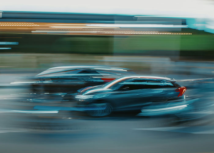 Blurred cars speeding on a crowded road, illustrating quick reactions that prevented a tragedy on busy streets.