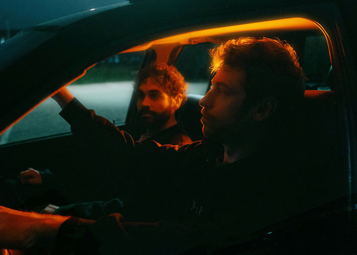 Two men inside a car at night, demonstrating quick reactions that prevented a potential tragedy on the road.
