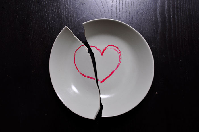 Broken white plate with a c*****d red heart painted on it, symbolizing rage room customers who need therapy instead.