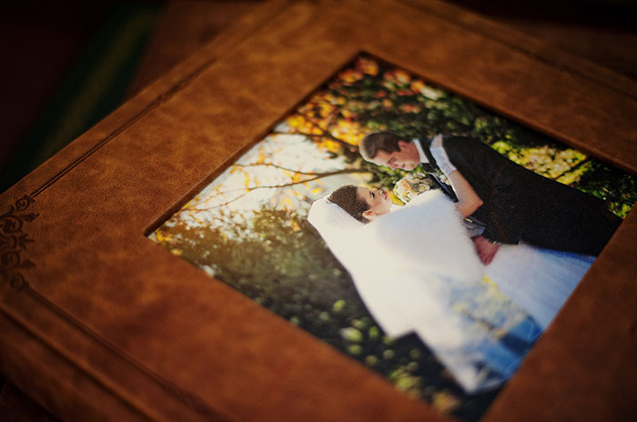 Wedding photo in a leather album cover showing bride and groom embracing outdoors, reflecting on rage room customers who need therapy.