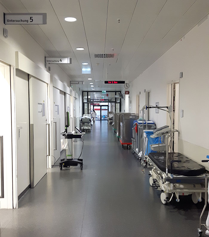 Empty hospital corridor with medical equipment illustrating therapy and rage room customers needing help.