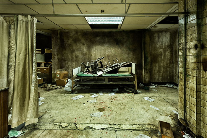 Abandoned, grimy room with broken furniture and scattered debris, evoking rage room customers needing therapy emotions.