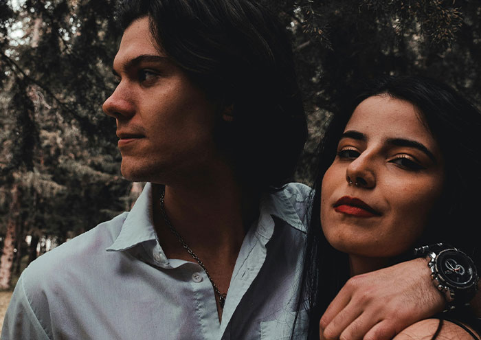 Young man and woman outdoors, with the man’s arm around her, conveying behavior that might make women feel unsafe.