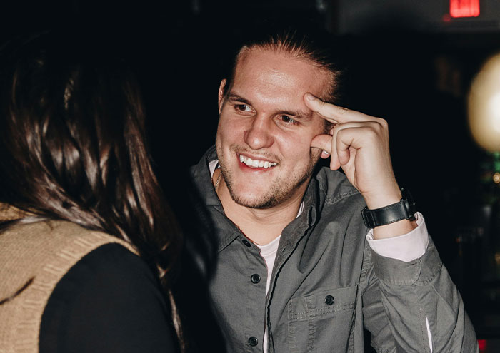 Man smiling and talking to a woman, illustrating behaviors from men that might make women feel unsafe, trust that gut feeling.