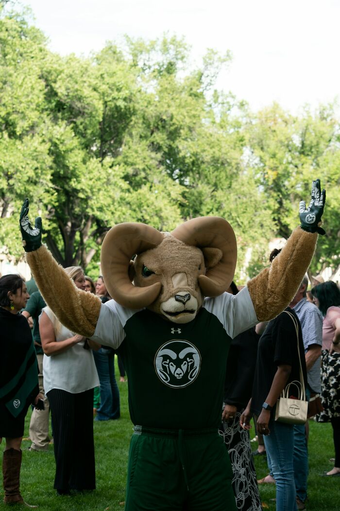 Ram mascot in sportswear raising arms at outdoor event with crowd, illustrating PR campaigns and decisions fails.