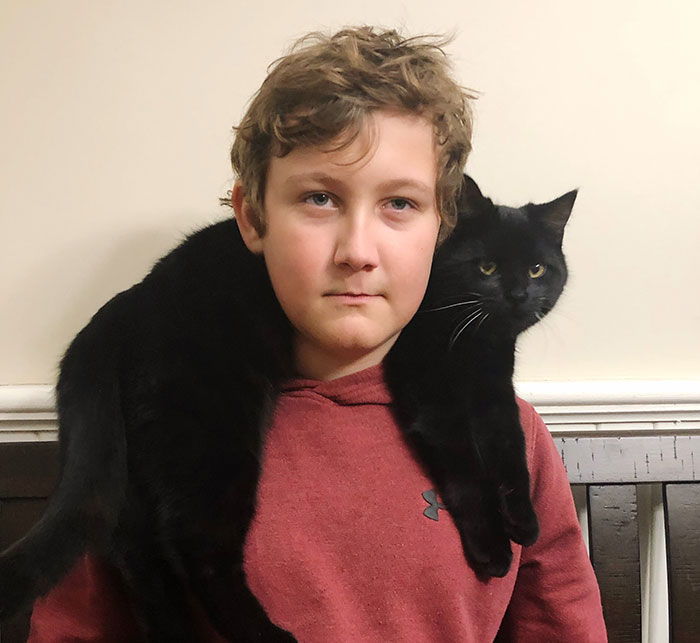 Young person with a black cat on their shoulders, symbolizing experiences of people who grew up with a psychopath.