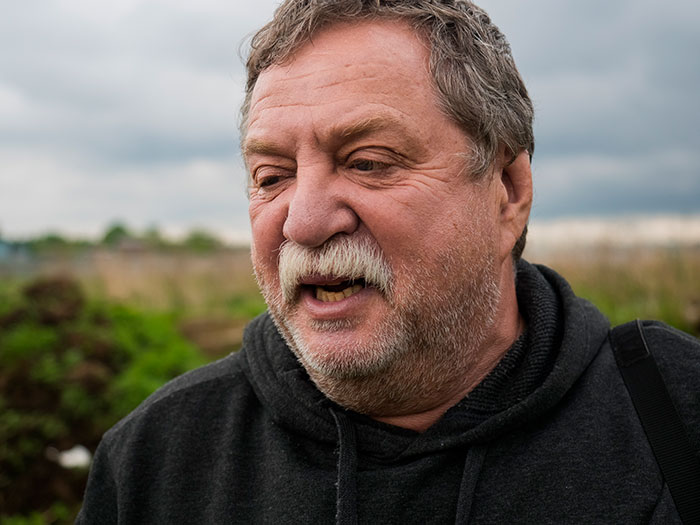 Middle-aged man outdoors sharing a story, reflecting on growing up with a psychopath and terrifying experiences.