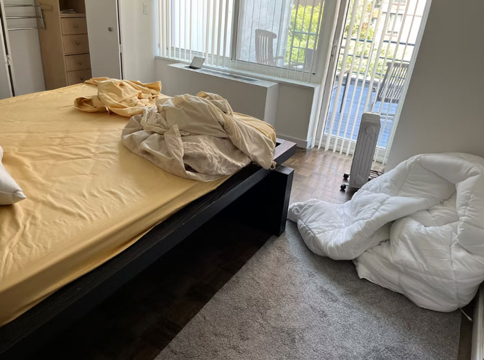 Untidy apartment bedroom with unmade bed and mattress, representing woman quits paying rent and apartment damage.