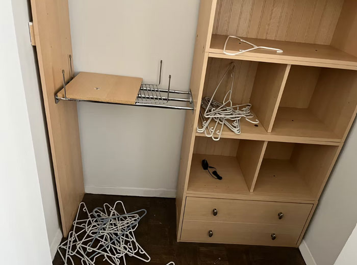 Damaged apartment closet with scattered hangers and broken shelf showing aftermath of tenant quitting rent conflict.