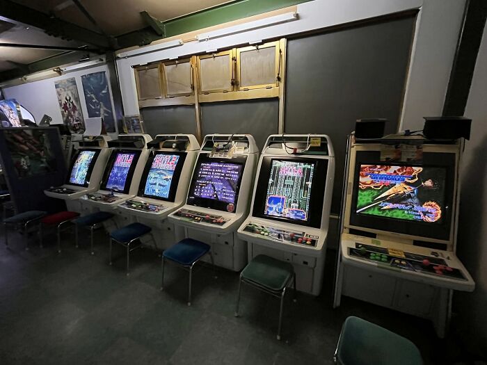 Row of retro gaming arcade machines with colorful screens in a nostalgic room for gaming fans from the ’80s to ’00s.