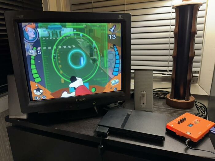 Retro gaming setup with classic CRT monitor, vintage console, and nostalgic handheld device on a desk at night.