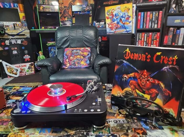 Retro gaming setup with vintage game posters, a record player, and nostalgic collectibles from the ’80s, ’90s, and ’00s.