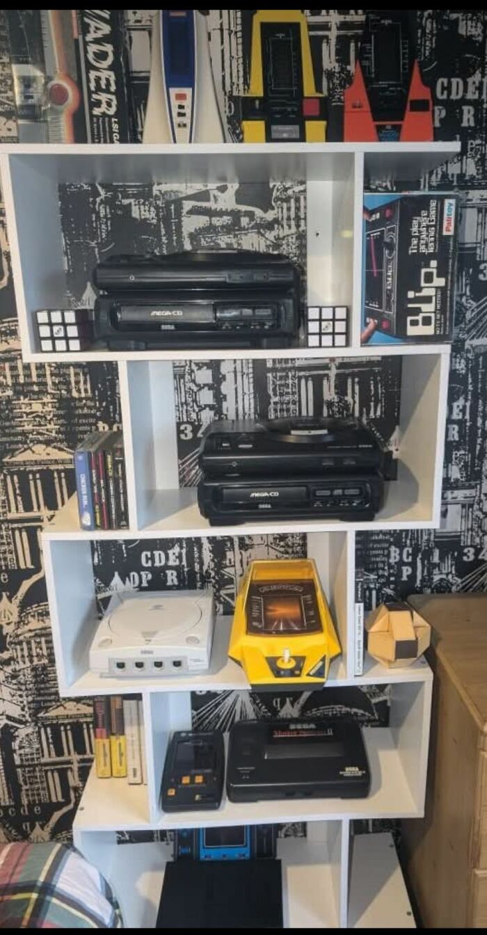 Shelf displaying retro gaming consoles, cartridges, and vintage nostalgia items from the ’80s, ’90s, and ’00s era.