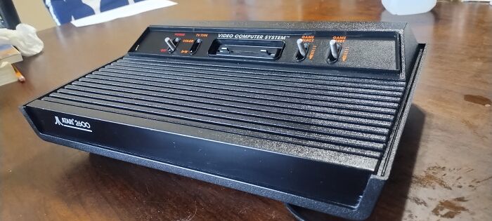 Atari 2600 retro gaming console on wooden table, a classic piece of 80s and 90s nostalgia for gamers.