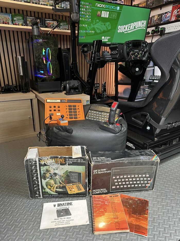 Retro gaming setup with vintage consoles, classic ZX Spectrum, joystick, and nostalgic gaming manuals from the 80s and 90s.