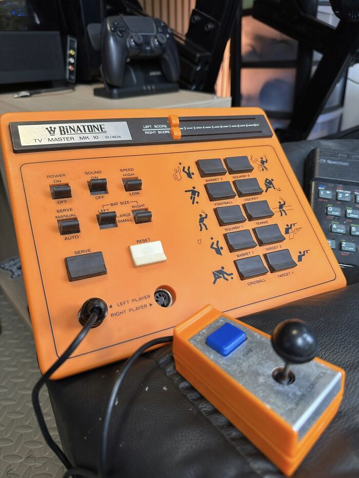 Orange Binatone TV Master MK 10 retro gaming console and joystick from the 80s with classic sports game buttons and controls.