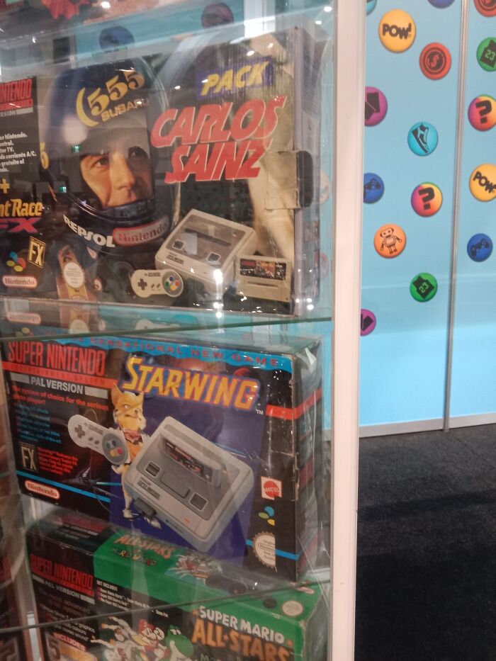 Retro gaming nostalgia with vintage Super Nintendo game boxes displayed in a glass case at an exhibit.
