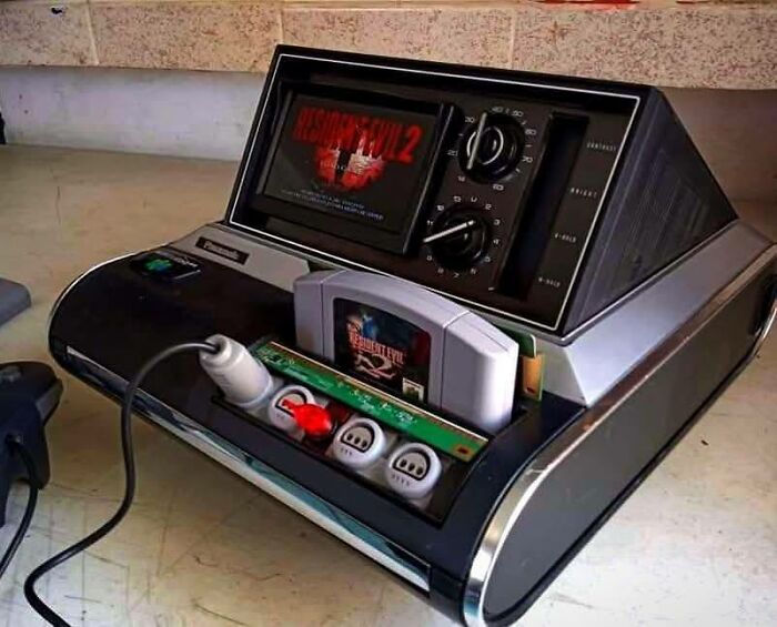 Vintage gaming console with Resident Evil 2 cartridge and wired controllers, capturing retro gaming and nostalgia vibes.