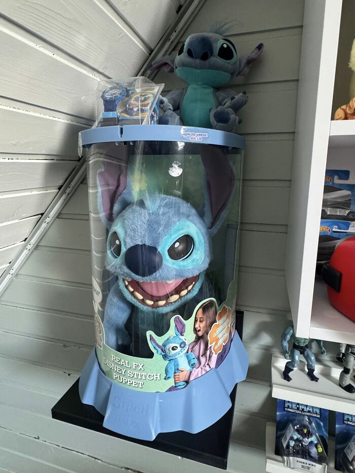 Real FX Disney Stitch puppet collectible displayed in a nostalgic retro gaming and memorabilia setting.