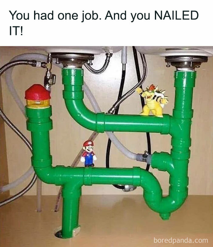 Green plumbing pipes under a sink styled like retro gaming pipes with Mario and Bowser figures for nostalgia.