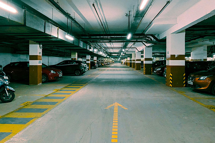 Underground parking garage with multiple luxury cars, illustrating absurd things rich people spend money on firsthand.
