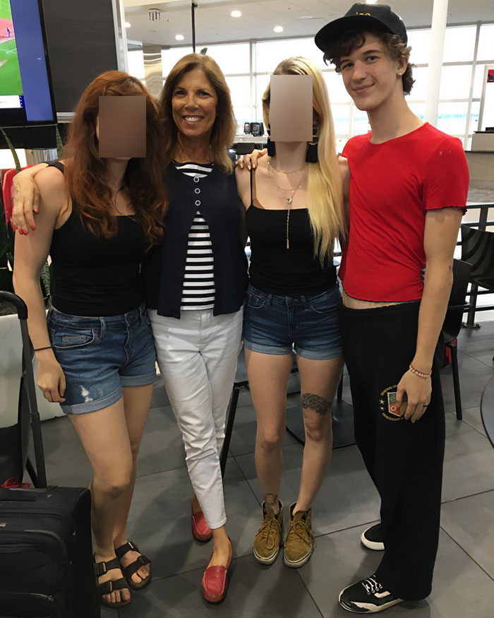 Woman standing with three young adults in casual clothes at an airport, related to Minneapolis school attacker&rsquo;s mother not cooperating.