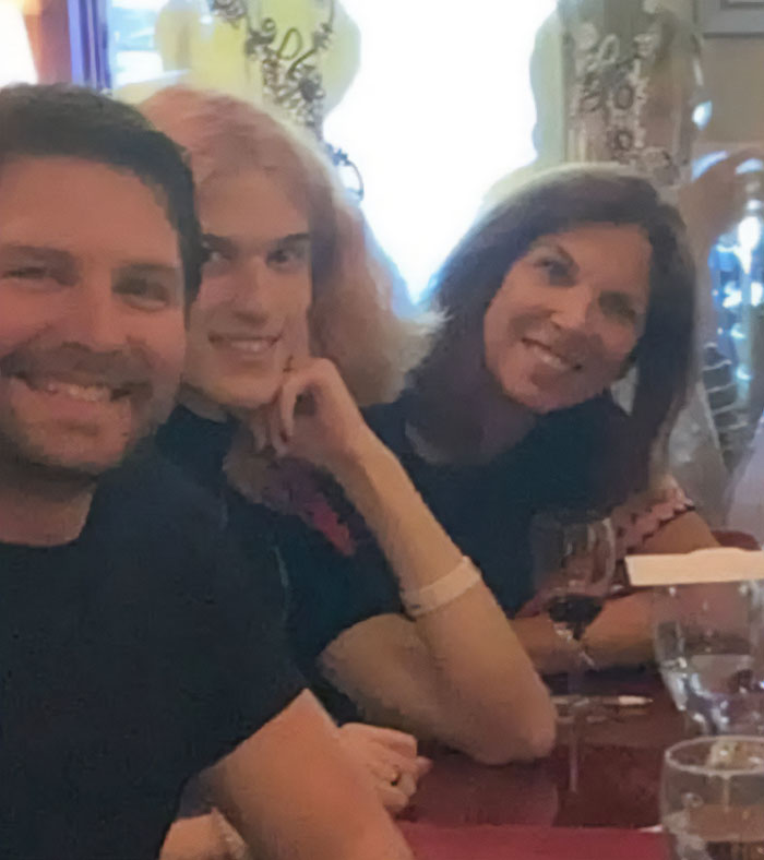 Three people sitting closely together at a table, related to Minneapolis massacre culprit photo and disturbing manifesto.