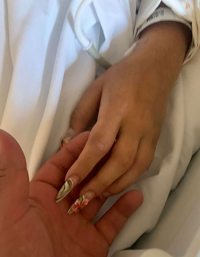 Close-up of two hands touching, one hand with floral nail art, illustrating an emotional connection in a horrific 7-Eleven manager case.