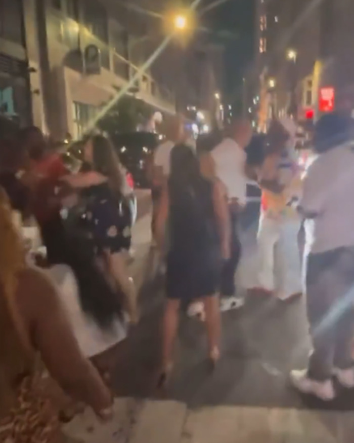 Crowd gathered on city street at night during Cincinnati brawl, showing tense interactions amid rising racial tensions.