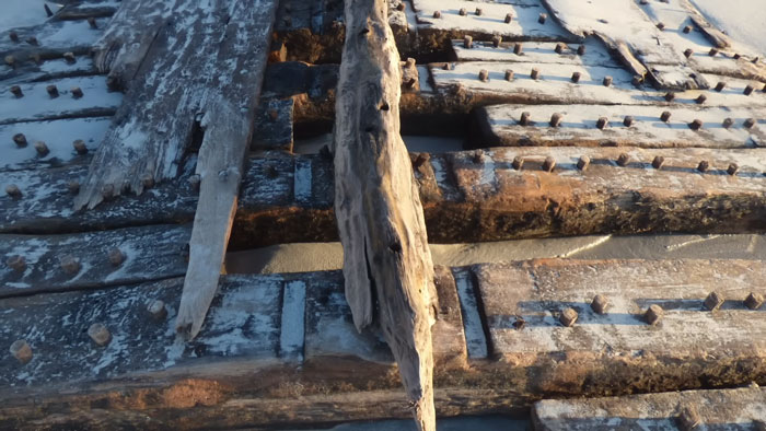 Close-up view of weathered wooden beams and rusted nails from the Sanday ship wreck showing aged textures and decay.