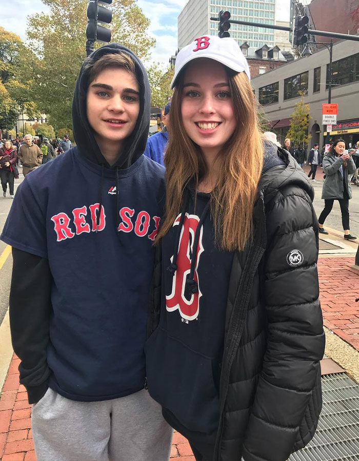 Two young people wearing Red Sox apparel outdoors, linked to shocking twist in violent Disney World incident involving family.