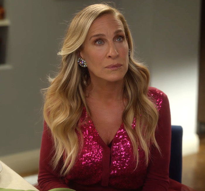 Sarah Jessica Parker wearing sparkly pink top, looking thoughtful during And Just Like That series finale scene. Sarah Jessica Parker wearing sparkly pink top, looking thoughtful during And Just Like That series finale scene.